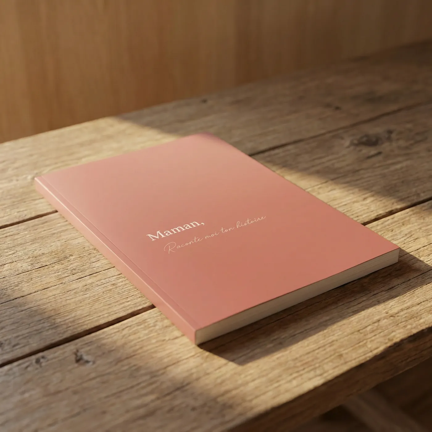 Livre Maman, Raconte-moi ton histoire posé sur une table en bois au soleil